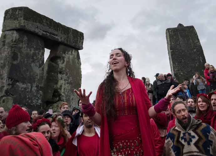 STONEHENGE, ENGLAND - DECEMBER 21: Members of the Shakti Sings choir sing as druids, pagans and revellers gather in the centre of Stonehenge, hoping to see the sun rise, as they take part in a winter solstice ceremony at the ancient neolithic monument of Stonehenge near Amesbury on December 21, 2016 in Wiltshire, England. Despite a forecast for cloud and rain, a large crowd gathered at the famous historic stone circle, a UNESCO listed ancient monument, to celebrate the sunrise closest to the Winter Solstice, the shortest day of the year. The event is claimed to be more important in the pagan calendar than the summer solstice, because it marks the 're-birth' of the Sun for the New Year. (Photo by Matt Cardy/Getty Images)