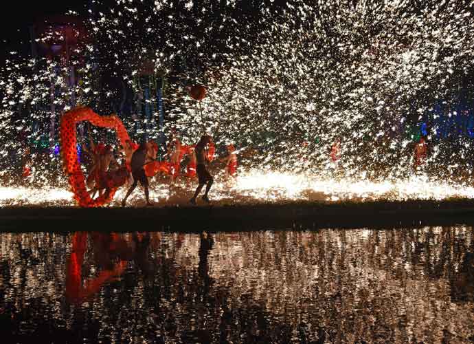 WUHAN, CHINA - JANUARY 30: Artists perform the fire dragon dance by a lake during a celebration for Spring Festival at Wuhan Happy Valley on January 30, 2017 in Wuhan, Hubei Province of China. Folk artists performed dragon dance with fireworks exploding around at Wuhan Happy Valley on the third day of Chinese Lunar New Year. (Photo by Miao Jian/Wuhan Morning Post/VCG via Getty Images)