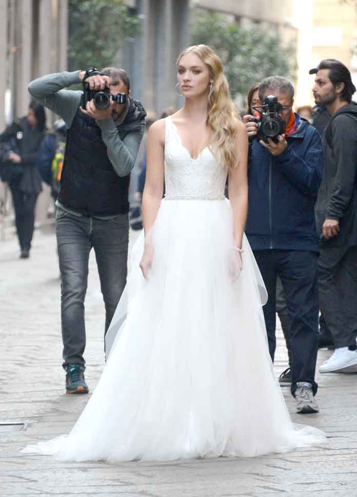 Roxy Horner, Leonardo DiCaprio's 'former flame,' is beautiful in bridal couture as she teams a gorgeous lace dress with trainers while filming a commercial for Eddy K in Milan, Italy.