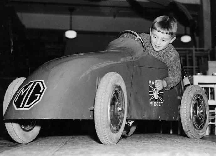 18th November 1934: A young boy trying out a toy MG Midget car at the famous toy shop Hamleys, on Regent Street, London. (Photo by Fox Photos/Getty Images)