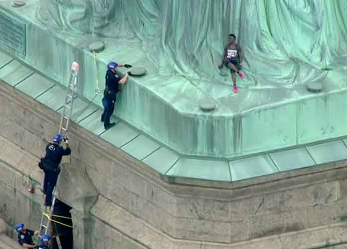 Woman climbs Statue of Liberty as Trump immigration policy protest