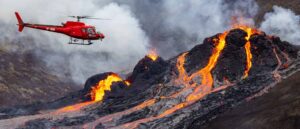 FAGRADALSFJALL, ICELAND - MARCH 20: (ICELAND OUT, no archiving and no use after 26th March 2021) A helicopter flies close to a volcanic eruption which has begun in Fagradalsfjall near the capital Reykjavik on March 20, 2021 in Fagradalsfjall, Iceland. On Friday the Icelandic meteorological office announced a volcano, referring to a mountain located south-west of the Capital Reykjavik has erupted after thousands of small earthquakes in the area over the recent weeks. A no-fly zone has been established in the area. (Photo by Vilhelm Gunnarsson/Getty Images)