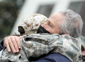 WASHINGTON, DC - APRIL 13: Comedian/activist Jon Stewart (R) gives a veteran a hug during a news conference on the benefits for veterans exposed to burn pits at the VFW Building on April 13, 2021 in Washington, DC. The phrase "burn pit" refers to an area of a deployed military base devoted to open-air burning of waste often using jet fuel as an accelerant. (Photo by Paul Morigi/Getty Images)