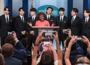 Members of Korean pop band BTS join Karine Jean-Pierre, White House press secretary, center, during a news conference in the James S. Brady Press Briefing Room at the White House in Washington, D.C., US, on Tuesday, May 31, 2022. BTS will meet with US President Joe Biden to address anti-Asian hate crimes and discrimination. Photographer: Oliver Contreras/Sipa/Bloomberg via Getty Images