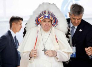 MASKWACIS, AB - JULY 25: Pope Francis wears a traditional headdress that was gifted to him by indigenous leaders following his apology during his visit on July 25, 2022 in Maskwacis, Canada. The Pope is touring Canada, meeting with Indigenous communities and community leaders in an effort to reconcile the harmful legacy of the church's role in Canada's residential schools. (Photo by Cole Burston/Getty Images)