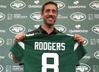 FLORHAM PARK, NEW JERSEY - APRIL 26: New York Jets quarterback Aaron Rodgers poses with a jersey during an introductory press conference at Atlantic Health Jets Training Center on April 26, 2023 in Florham Park, New Jersey. (Photo by Elsa/Getty Images)