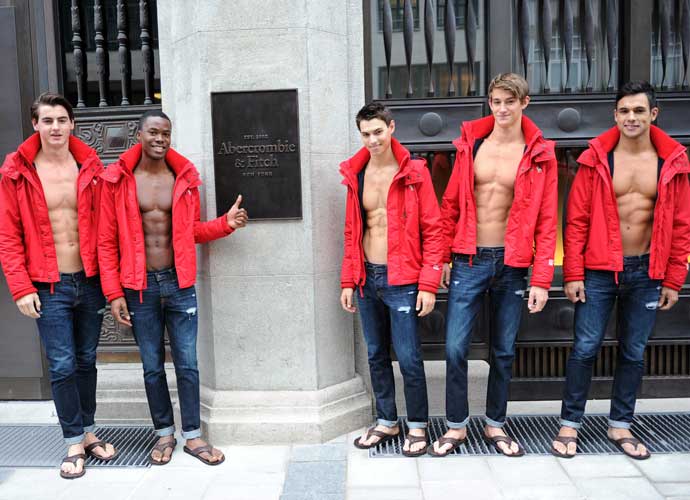 MUNICH, GERMANY - OCTOBER 25: Young women pose for photographs with male models outside the Abercrombie & Fitch flagship clothing store during the opening of Abercrombie & Fitch Munich flagship store on October 25, 2012 in Munich, Germany. (Photo by Hannes Magerstaedt/Getty Images)