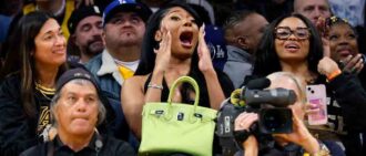 LOS ANGELES, CALIFORNIA - APRIL 7: Rapper Megan Thee Stallion, holding her Birkin bag, cheers for D'Angelo Russell #1 of the Los Angeles Lakers after scoring a three point basket during the second half against the Minnesota Timberwolves at Crypto.com Arena on April 7, 2024 in Los Angeles, California. (Photo by Kevork Djansezian/Getty Images)