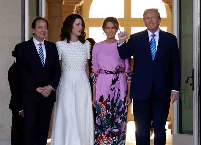PALM BEACH, FLORIDA - APRIL 06: Republican presidential candidate and former US President Donald Trump (R) and former first lady Melania Trump (2nd-R) arrive at the home of John Paulson (L) with Alina de Almeida (2nd-L) on April 6, 2024 in Palm Beach, Florida. Trump's campaign is expecting to raise more than 40 million dollars, when major donors gather for a fundraiser billed as the 