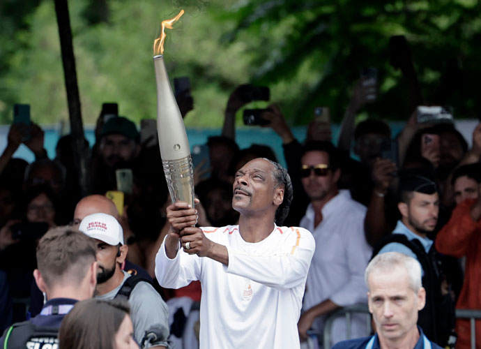 PARIS, FRANCE JULY 26 US rapper Snoop Dogg holds the torch as part